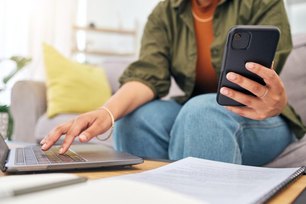 ¿Qué conviene mirar primero en un préstamo: la cuota o el costo total? Persona Mirando El Celular Con Una Libreta Al Lado 1024x683